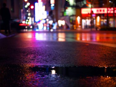 都会のネオンが濡れた道路に反射